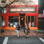 Two people walking outside of Sound Heritage on Victoria Crescent