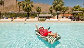 Santa relaxing on a floaty in the pool in Palm Springs