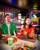 Couple laughing while enjoying a spread of dips and pizza.