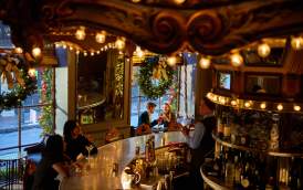 A couple enjoys holiday cocktails in the festive environment of the Carousel Bar in Hotel Monteleone.