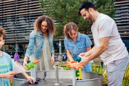 Family playing with an outdoor water feature in birmingham