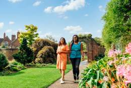 Two people walking down a path outside of Exploring Winterbourne House and Garden in Birmingham