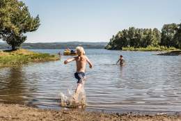 Ivrig gutt løper på sandstranden hos Sveastranda Camping