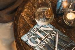 A table with a leaflet for the Beverley Gin Festival, surrounded by drinking glasses.