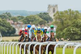 Horses and jockeys racing at Beverley racecourse.