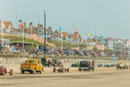 a parade of cars on south beach Bridlington with crowds watching from the promenade.