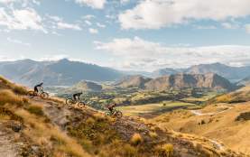 Three mountain bikers on Pack Track and Sack Trail, Coronet Peak
