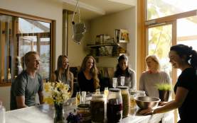 A group of people sitting around a kitchen island during a food workshop