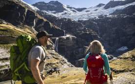 Couple hiking underneath glacier at Earnslaw Burn