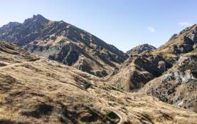 Wide view of a mountain bike trail through striking rugged mountains