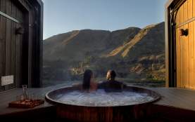 Two people in a hot tub with a beautiful mountain view