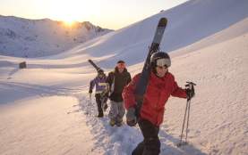 Group of people walking up The Remarkables Ski Area with skis