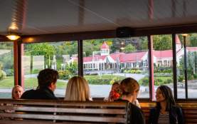 A group of people sitting on the TSS Earnslaw with a view of Walter Peak through the windows