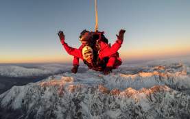 Skydiver high above snowcapped mountains of Queenstown