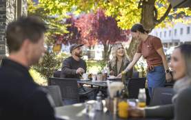 Waitress serving customers in a pretty outdoor autumn setting