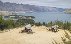 Bikers riding Queenstown Bike Park in Queenstown with Remarkables Mountains in the background