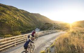 Couple cycling the Gibbston River Wine Trail