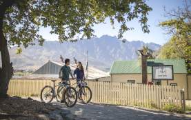Couple biking The Queenstown Trail, by the Boat Shed Cafe