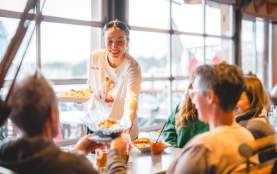 A server handing out plates of food.