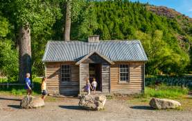 Family in front of the historic Arrowtown Police Hut