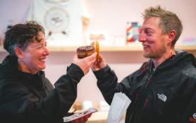 Two people cheering different baked goods together.