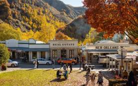 Street view of an old historic town with autumnal trees and mountains in the background