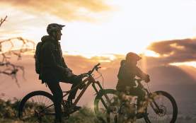 Silhouette of father and son on mountain bikes at sunrise