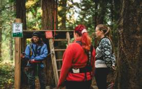 A Wildplay trainer teaching people how to equip the climbing carabiner.