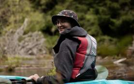 A person in a kayak facing the camera, smiling