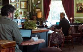 Inside of a cafe with people working on their laptops and ordering food.