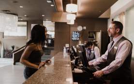 A person checking into the front desk of a hotel.