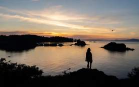 A person looking over pipers lagoon as the sun sets.