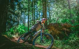 A man turning a corner while biking on a dirt trail