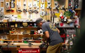 Darryl Tatom, Owner of Small Planet in workshop surrounded by sporting gear