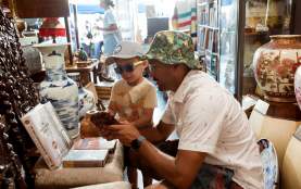 A relaxed moment inside a Nanaimo vintage shop, where an adult and child explore together among shelves of unique antiques and collectibles.