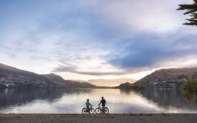Two people admiring the view along Kelvin Heights Peninsula during a morning bike ride