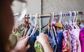 A person shifting through a clothes rack.