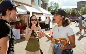 People talking while eating fair food.