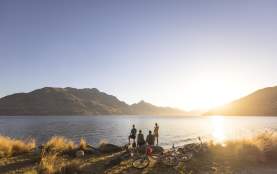 Family with bikes stops to admire views over Lake Whakatipu from Queenstown Gardens