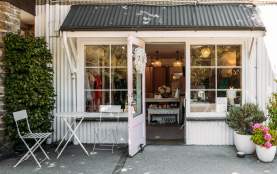 Outside view of a a white, cottage-style looking boutique shop