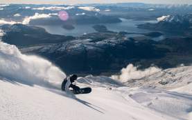 Snowboarder at Treble Cone with lakes and mountains in the background