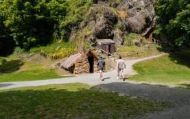 People exploring the historic Chinese Village huts in Arrowtown