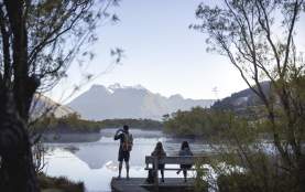 People at the Glenorchy Lagoon Walkway lookout, overlooking lake and mountains