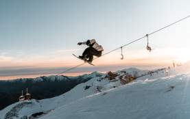 Snowboarder doing a trick at Coronet Peak at Sunset