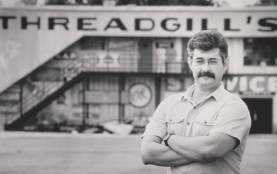 Photo of Eddie Wilson standing in front of his restaurant and music venue Threadgills in Austin Texas