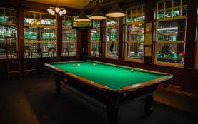 A pool table in dim lighting.