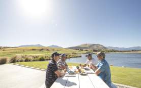 Ground of friends eating outdoors next to lake and mountains