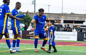 A group of three Westchester Soccer players high five a junior player.