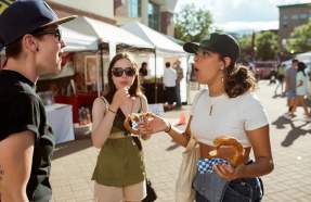 People talking while eating fair food.