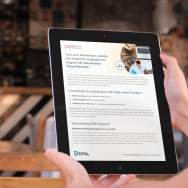 Hand holding a tablet displaying a Granicus Destinations travel network guide, with a blurred café background.